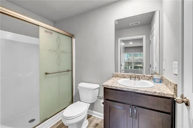 a bathroom with a granite countertop sink toilet and shower
