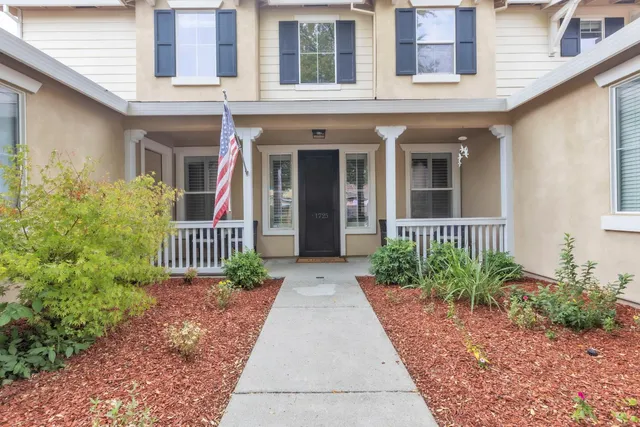 a dining room with furniture and potted plants