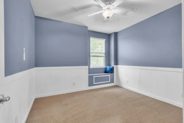 an empty room with windows and fan
