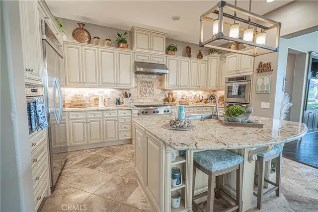 a kitchen with stainless steel appliances granite countertop a stove top oven a sink a counter top space and cabinets
