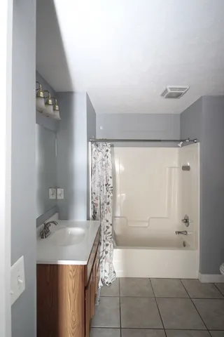 a bathroom with a granite countertop sink a toilet and shower