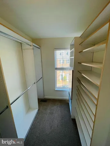 a view of an empty room with chandelier and a window