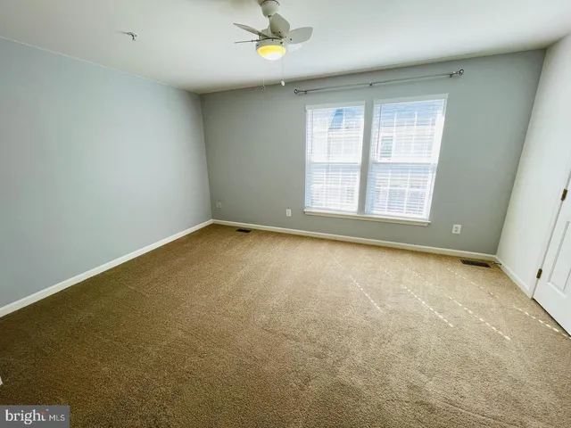 an empty room with windows and cabinet