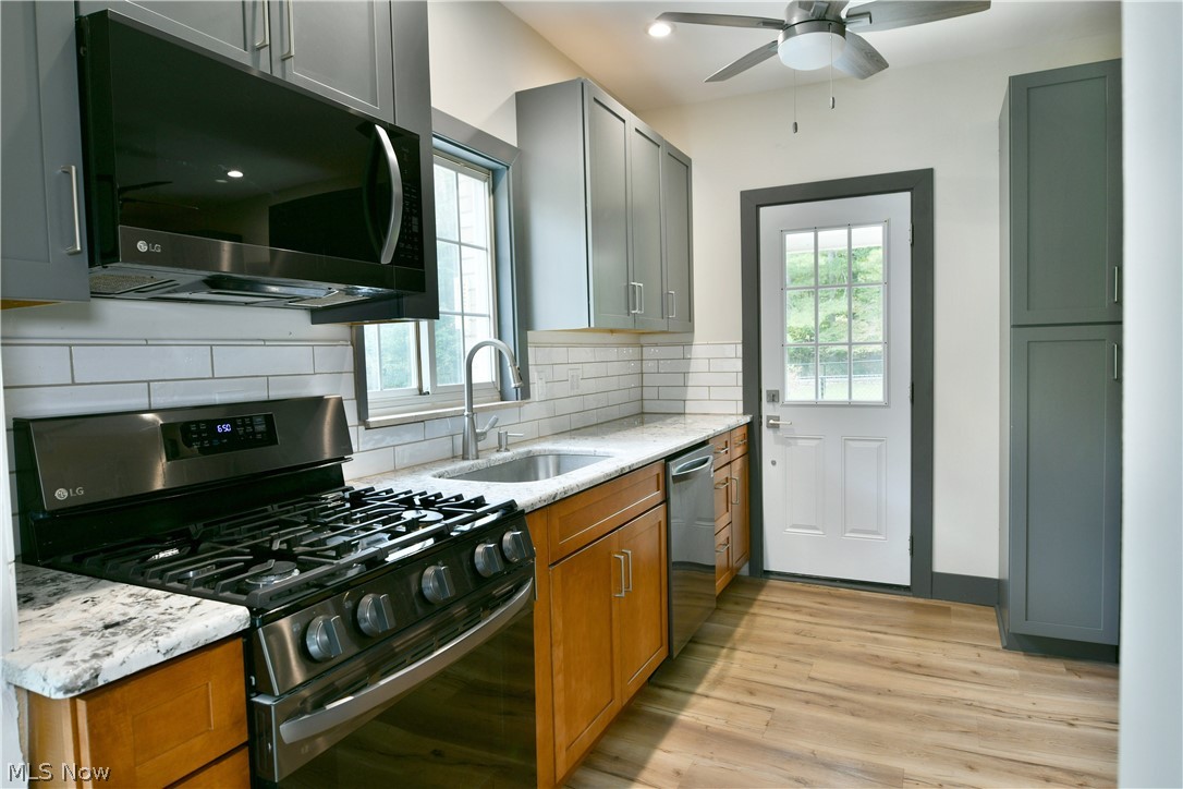 892 Yankee Run Road Masury, OH 44438 - Photo 16 of 50 Contemporary kitchen featuring gray upper cabinetry, natural wood-finish lower cabinetry, and a white subway tile backsplash