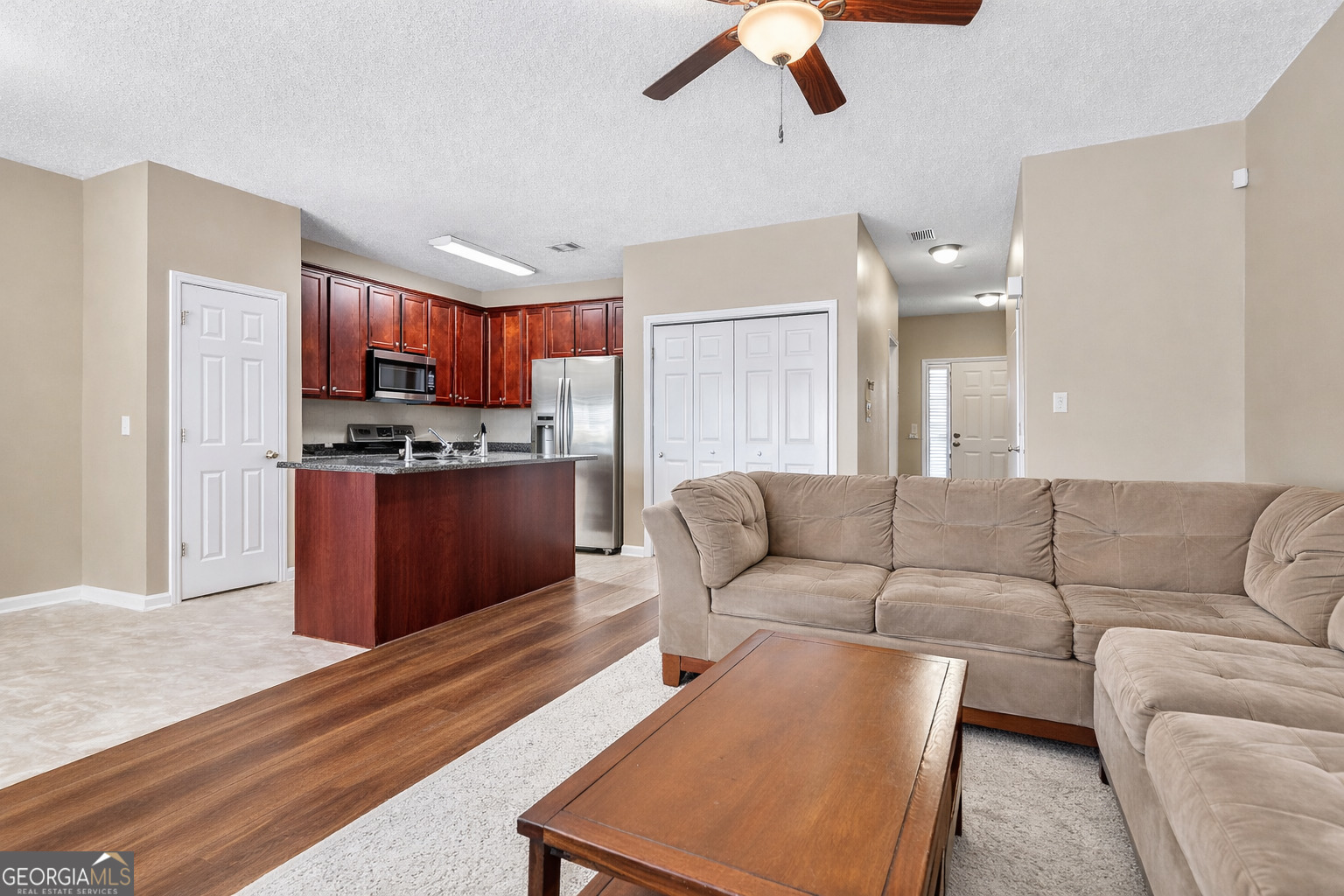 7759 Bucknell Terrace Fairburn, GA 30213 - Photo 9 of 26 a living room with furniture and a kitchen view