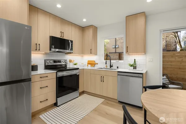a kitchen with cabinets stainless steel appliances and sink