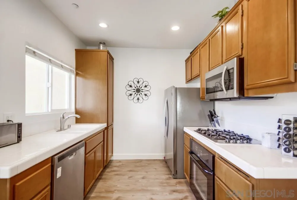 9728 Marilla Drive, Unit 312 Lakeside, CA 92040 - Photo 9 of 28 a kitchen with stainless steel appliances granite countertop a sink stove and refrigerator