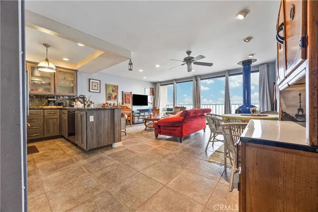 a living room with furniture a kitchen view and a large window