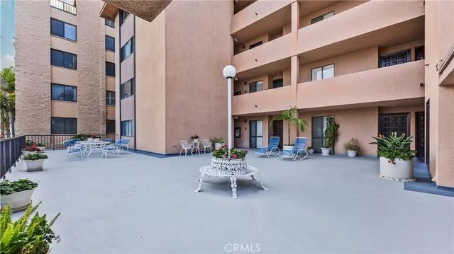a view of a building with sitting area and potted plants