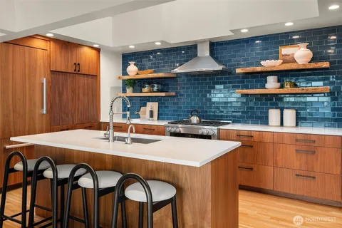 a kitchen with a sink a stove and chairs