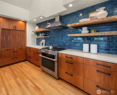a kitchen with stainless steel appliances granite countertop a sink and wooden cabinets