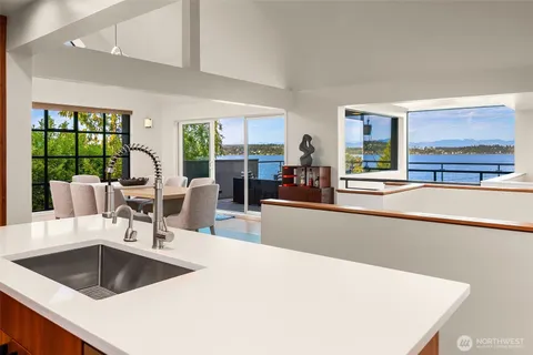 a kitchen with a sink and large windows