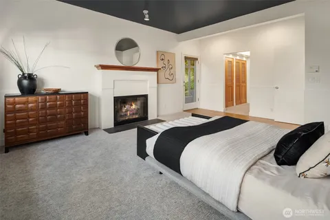 a bedroom with a bed a fireplace and a chandelier