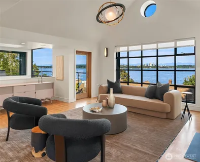 a living room with furniture kitchen and a large window