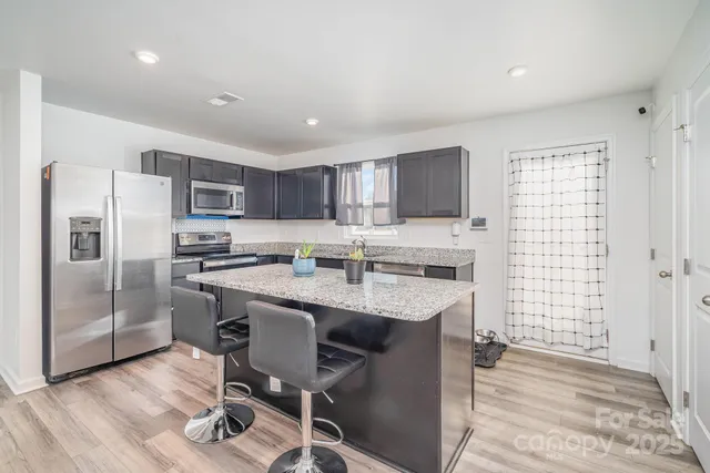 a kitchen with kitchen island a sink stove and refrigerator