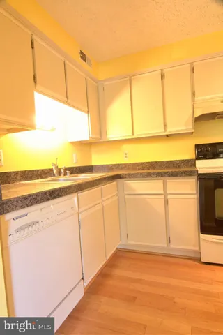 a view of a kitchen with kitchen island and wooden floor