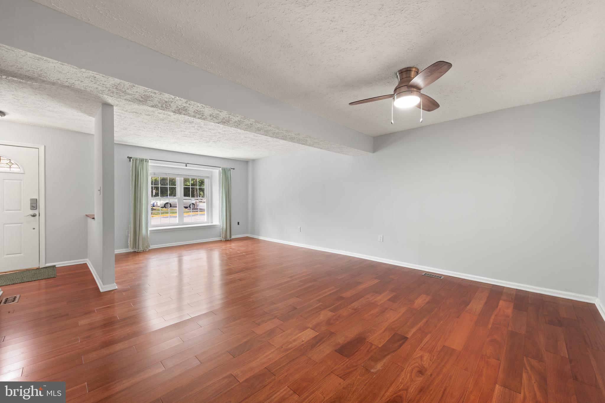 11321 Crescendo Place Silver Spring, MD 20901 - Photo 19 of 24 an empty room with wooden floor chandelier fan and windows