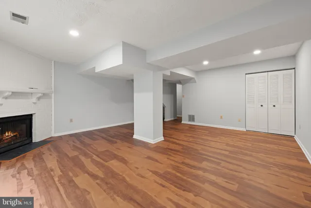 a view of empty room with wooden floor and fireplace