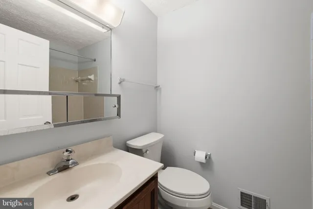 a bathroom with a sink a toilet and mirror
