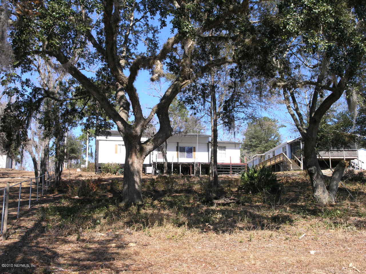 6786 Deer Springs Road Keystone Heights, FL 32656 - Photo 3 of 6 a tree in front of a white house
