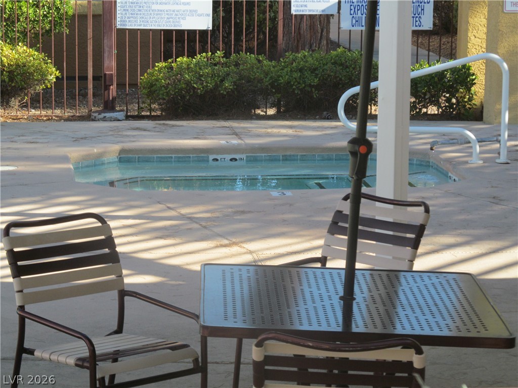 7950 West Flamingo Road, Unit 2048 Las Vegas, NV 89147 - Photo 23 of 24 An inviting hot tub awaits relaxation, perfectly complemented by comfortable poolside seating.