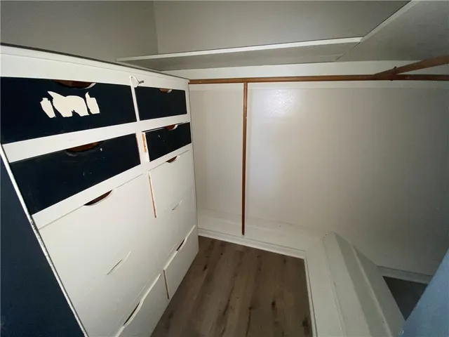 a view of walk in closet with wooden floor