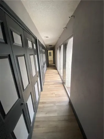 a view of a hallway with wooden floor and staircase