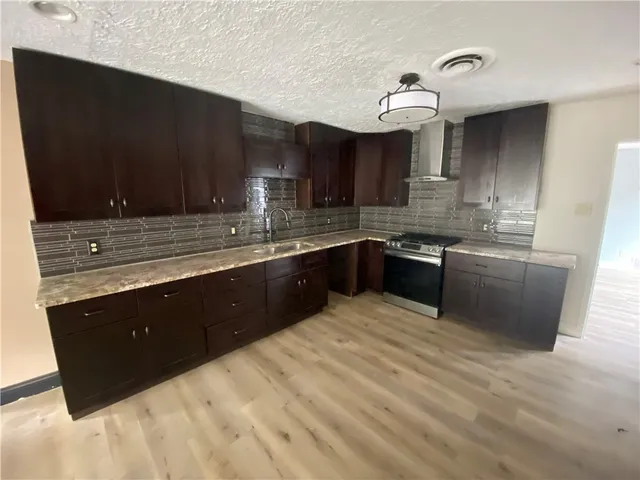 a kitchen with stainless steel appliances granite countertop a sink stove and cabinets