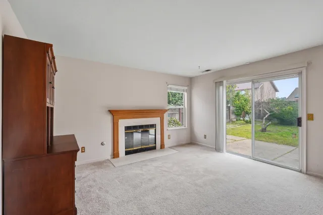 a view of empty room with a fireplace and window