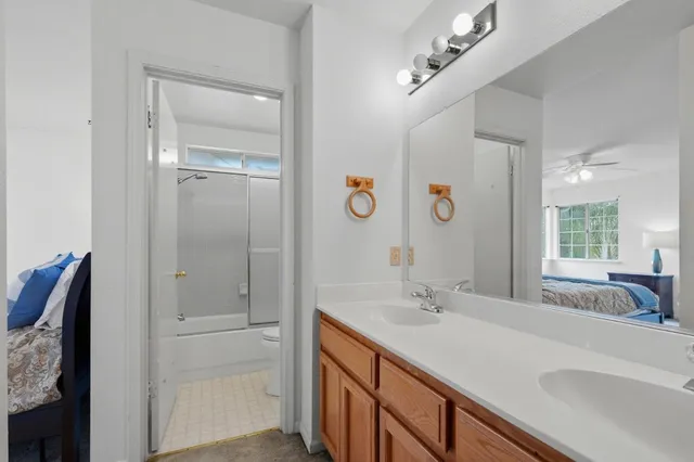 a spacious bathroom with a double vanity sink a mirror and shower