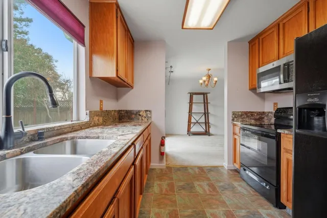a kitchen with stainless steel appliances granite countertop a sink and a stove