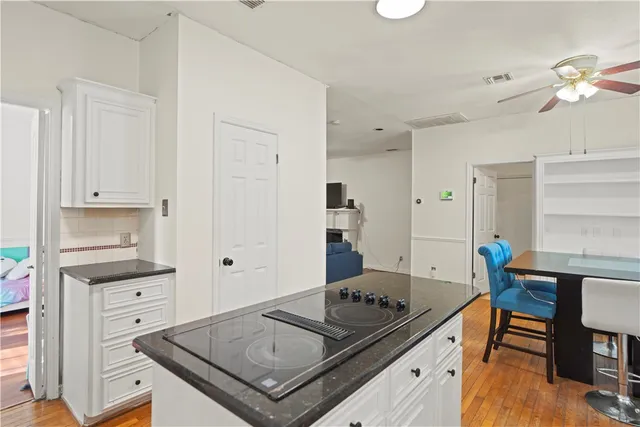 a bathroom with a granite countertop toilet a sink and a mirror