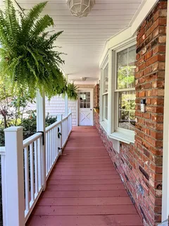 a view of a porch with wooden floor and fence