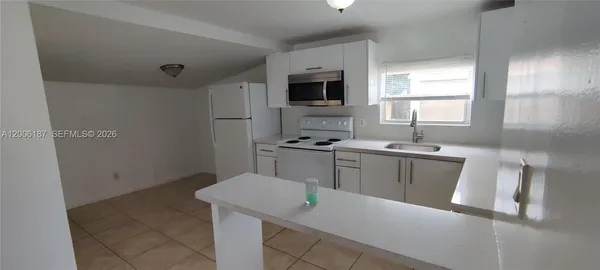 a kitchen with a sink cabinets and a refrigerator