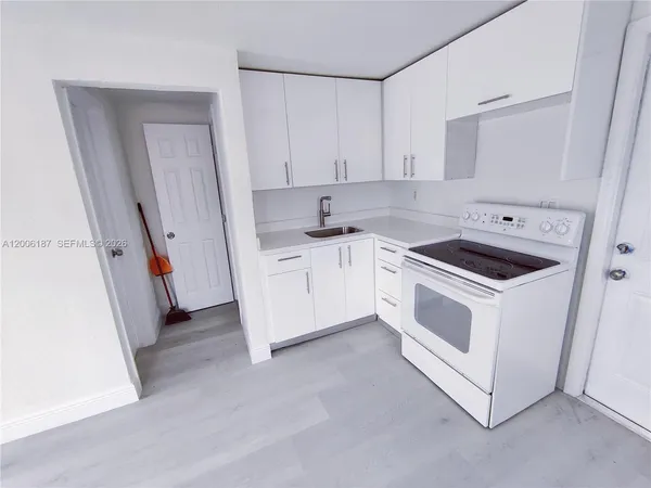 a kitchen with granite countertop white cabinets and white appliances