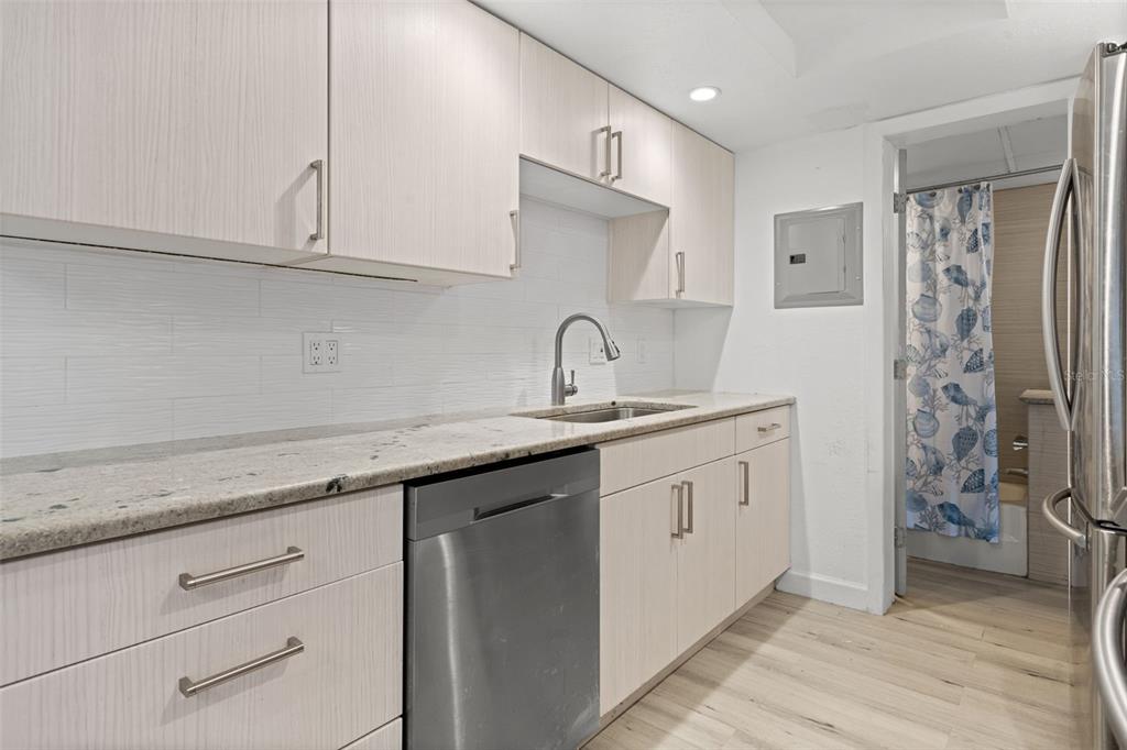 8921 Blind Pass Road, Unit 142 St. Pete Beach, FL 33706 - Photo 12 of 22 a kitchen with stainless steel appliances granite countertop a sink and a refrigerator