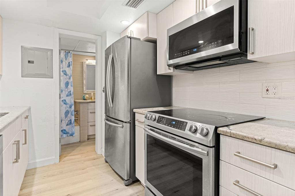 8921 Blind Pass Road, Unit 142 St. Pete Beach, FL 33706 - Photo 15 of 22 a kitchen with a stove and a microwave