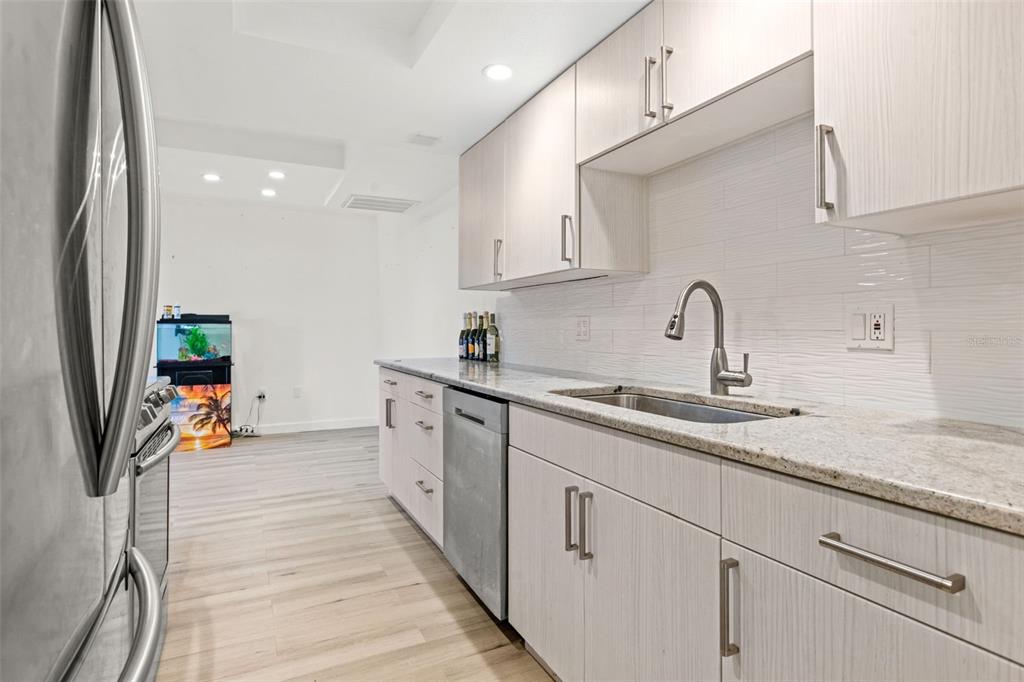 8921 Blind Pass Road, Unit 142 St. Pete Beach, FL 33706 - Photo 16 of 22 a kitchen with stainless steel appliances granite countertop a sink and cabinets