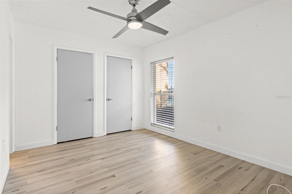 8921 Blind Pass Road, Unit 142 St. Pete Beach, FL 33706 - Photo 17 of 22 wooden floor in an empty room with a window