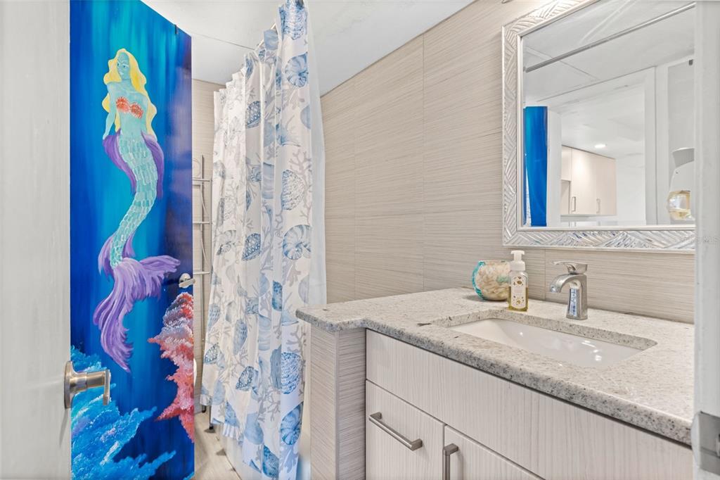8921 Blind Pass Road, Unit 142 St. Pete Beach, FL 33706 - Photo 18 of 22 a bathroom with a sink mirror and vanity