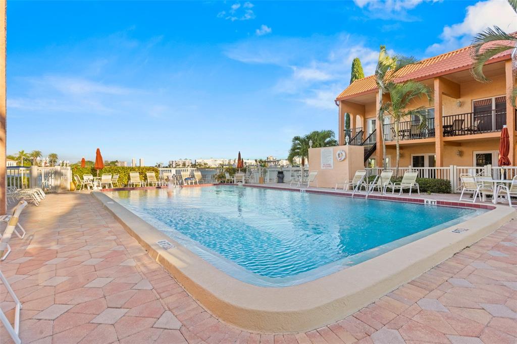 8921 Blind Pass Road, Unit 142 St. Pete Beach, FL 33706 - Photo 19 of 22 a view of swimming pool with outdoor seating and lake view