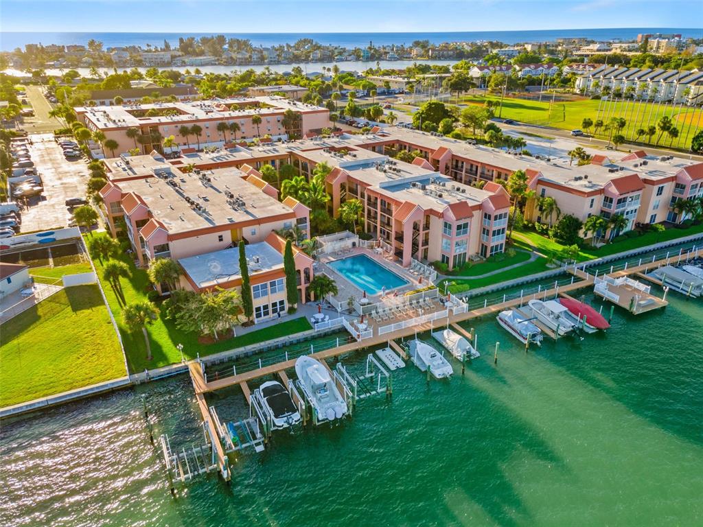 8921 Blind Pass Road, Unit 142 St. Pete Beach, FL 33706 - Photo 4 of 22 an aerial view of residential houses with outdoor space and swimming pool