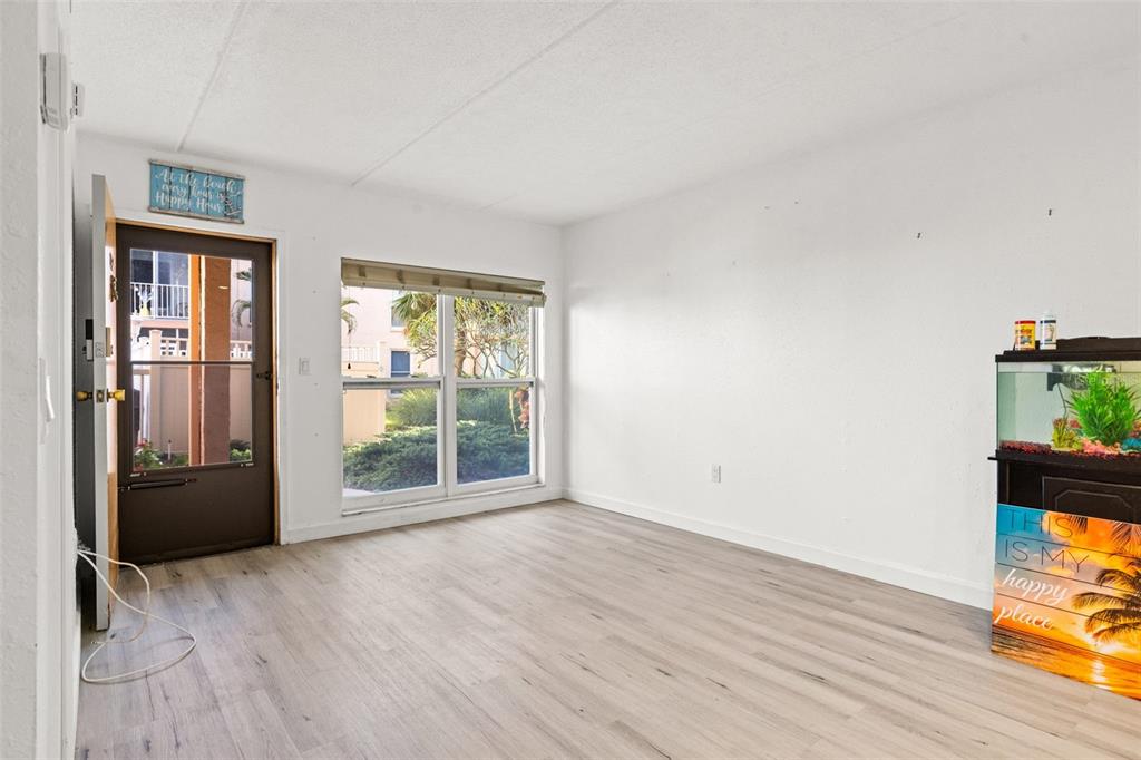 8921 Blind Pass Road, Unit 142 St. Pete Beach, FL 33706 - Photo 8 of 22 wooden floor in an empty room with a window