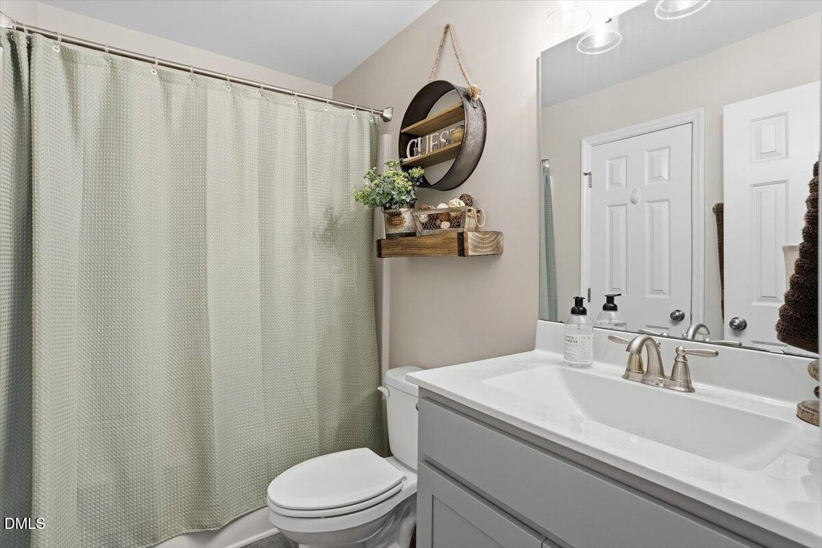 605 Oak Run Drive Raleigh, NC 27606 - Photo 11 of 28 a bathroom with a sink vanity mirror and toilet