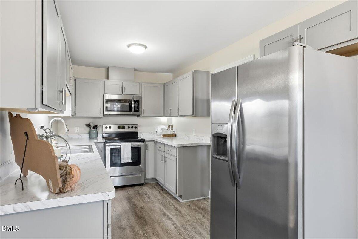 605 Oak Run Drive Raleigh, NC 27606 - Photo 14 of 28 a kitchen with kitchen island a counter top space cabinets stainless steel appliances and a sink