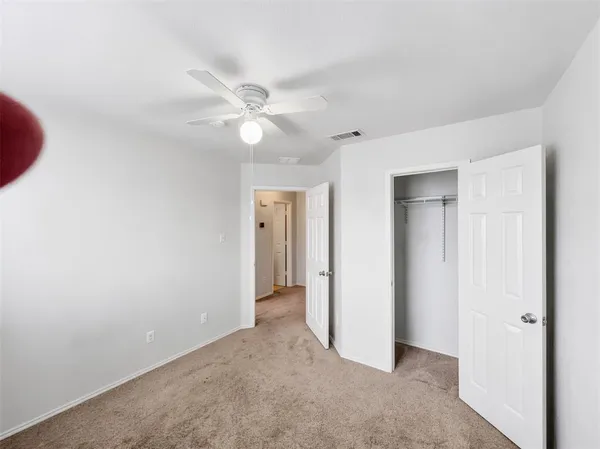 a view of a big room with closet and a ceiling fan