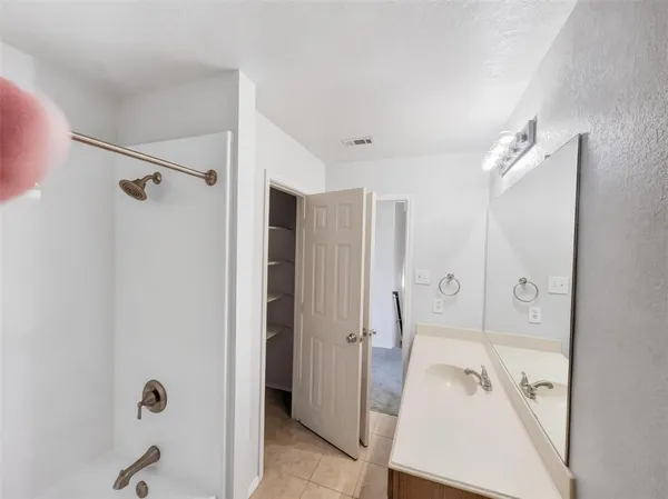 a bathroom with a tub shower view and a sink