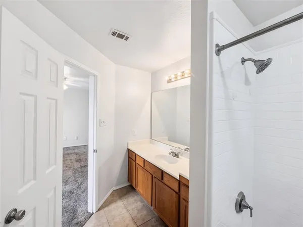 a bathroom with a granite countertop sink a mirror and a bathtub