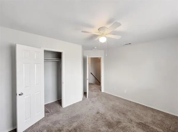an empty room with a ceiling fan and a window