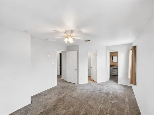 an empty room with fan and entrance